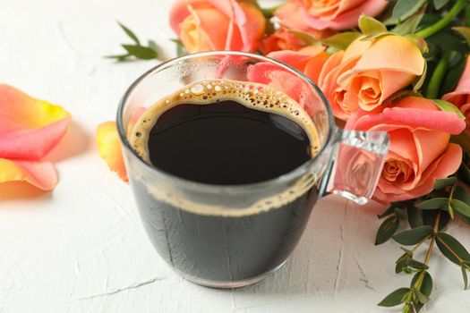 Cup of coffee and pink roses on white background, closeup