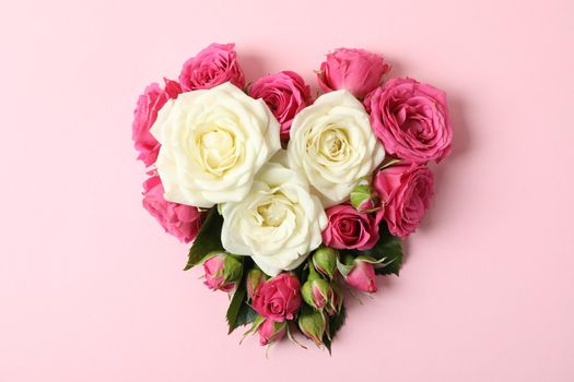 Beautiful roses in shape of heart on color background