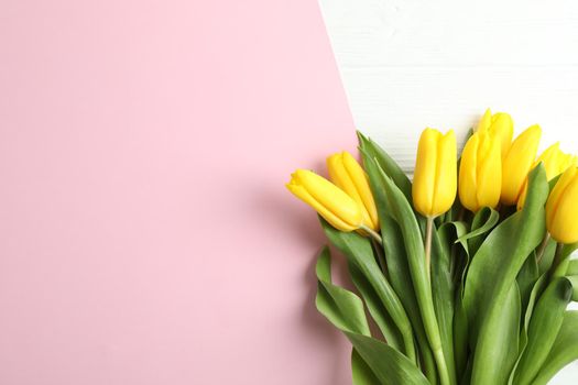 Beautiful bouquet of yellow tulips on color background, top view. Space for text