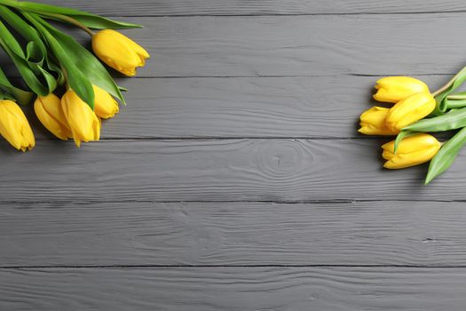 Beautiful yellow tulips on wooden background, space for text. Top view