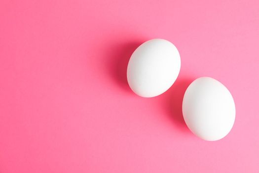 Chicken eggs on pink background, space for text