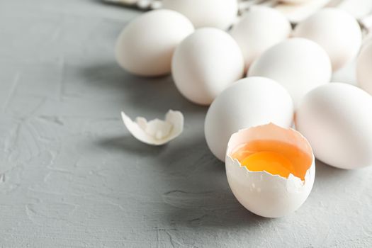 White chicken eggs and kitchen towel on grey background, space for text and closeup