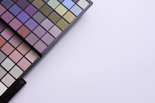 Colorful bright eye shadows. Professional multicolor eyeshadow palette. Professional multicolor eye shadow makeup palette on a white background, close-up. Makeup palette set. empty space