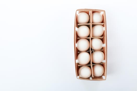 White chicken eggs in carton box isolated on white background, top view