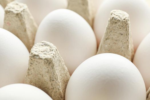 White chicken eggs in carton box as background, closeup