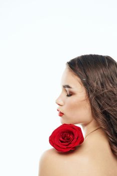 Back view of attractive brunette with red rose on naked shoulder. High quality photo