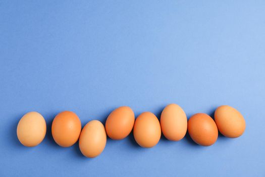 Chicken eggs on color background, space for text