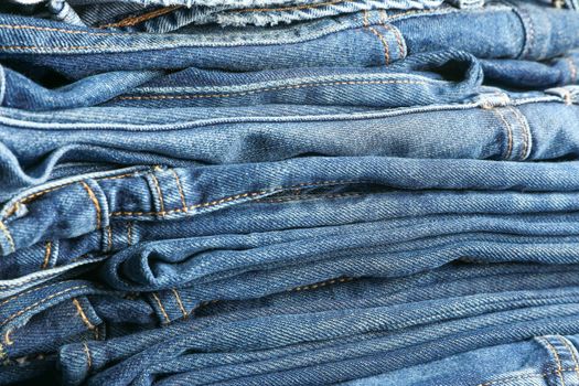 Stack of blue jeans as background, space for text