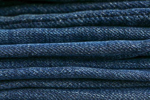 Stack of blue jeans as background, space for text