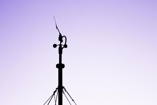 Weather station in silhouette over the sky at sunset. No people