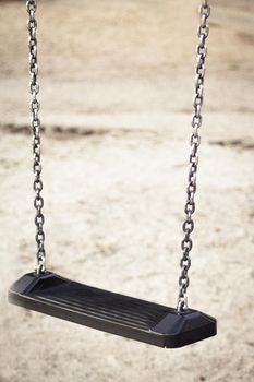 Wooden swing with metal chains for children. No people