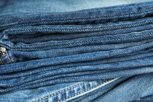 Stack of blue jeans as background, space for text