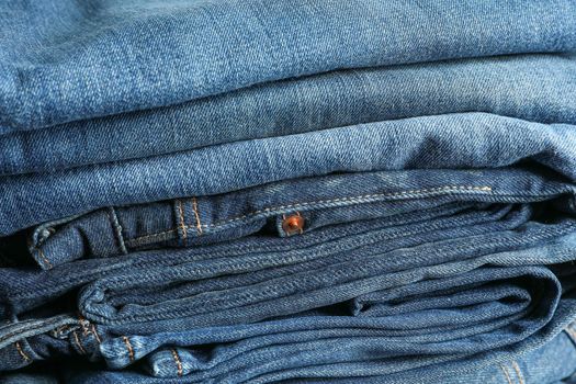 Stack of blue jeans as background, space for text