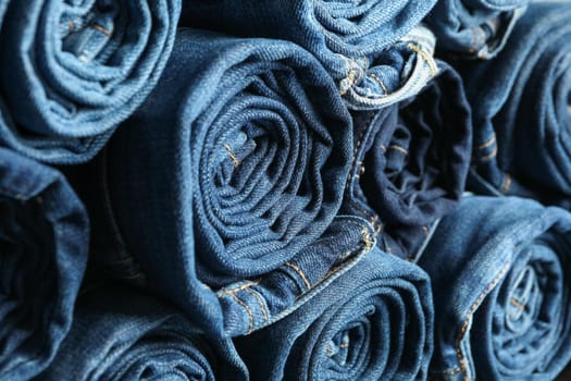 Stack rolled jeans texture on whole background, close up