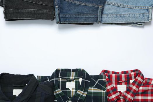 Flat lay with shirts and jeans on white background