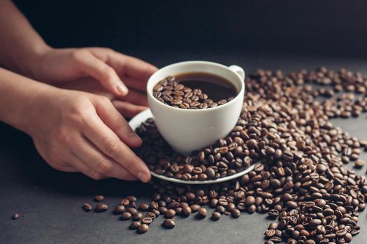 cup of coffee in female hands on a gray background morning breakfast aroma. High quality photo