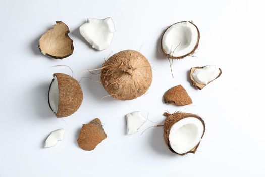 Flat lay composition with split coconut and its pieces on white background