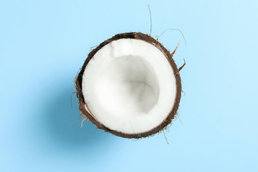 Half tropical coconut on color background, space for text