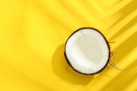 Half tropical coconut on color background, space for text