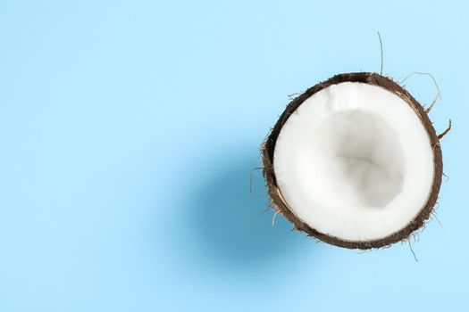 Half tropical coconut on color background, space for text