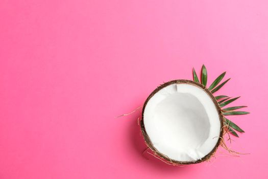 Half tropical coconut on color background, space for text