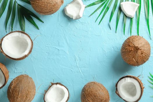 Tropical coconuts with palm branches on color background, space for text