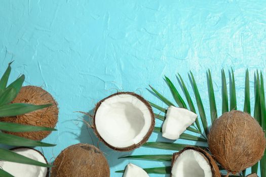 Tropical coconuts with palm branches on color background, space for text