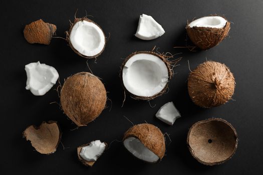 Flat lay composition with coconuts on black background