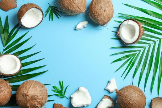 Tropical coconuts with palm branches on color background, space for text