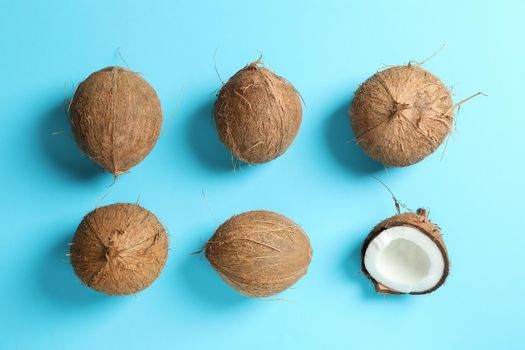 Flat lay composition with coconuts on color background