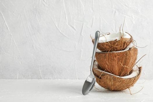 Stack tropical coconut with spoon on wooden table against white background