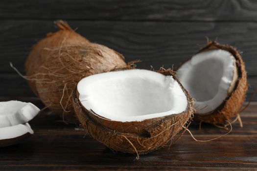 Coconuts on wooden table against dark background