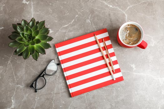 Flat lay composition with cup of coffee, copybook and succulent plant, top view