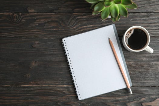 Flat lay composition with cup of coffee, copybook, pencil and succulent plant, space for text