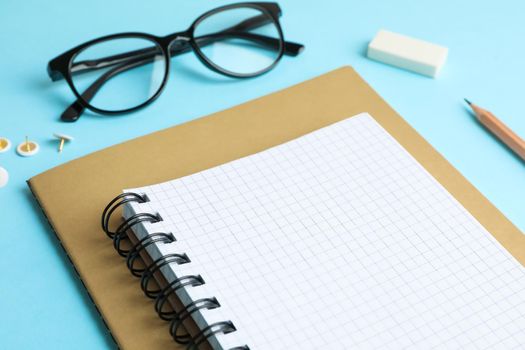 Copybooks, pencil and glasses on color background, space for text