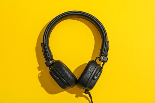 Headphones on color background, space for text