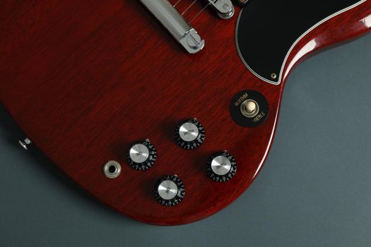 Beautiful six - string electric guitar on dark background, closeup