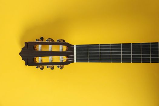 Guitar neck on yellow background, space for text