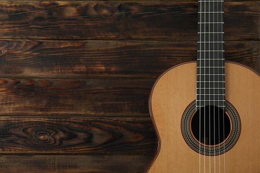 Beautiful six - string classic guitar on wooden background, space for text