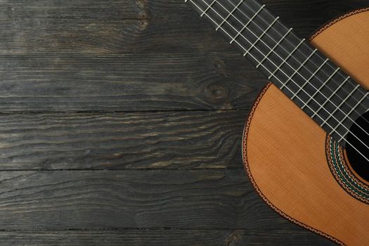 Beautiful six - string classic guitar on wooden background, space for text