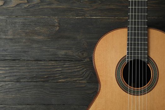 Beautiful six - string classic guitar on wooden background, space for text