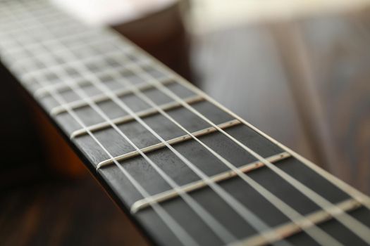 Guitar neck against wooden background, space for text