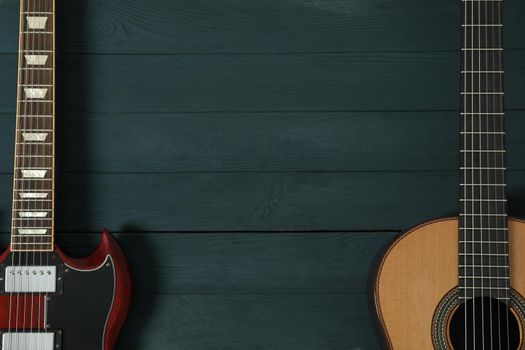 Electric and classic guitar on wooden background, space for text