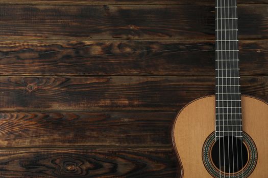 Beautiful six - string classic guitar on wooden background, space for text