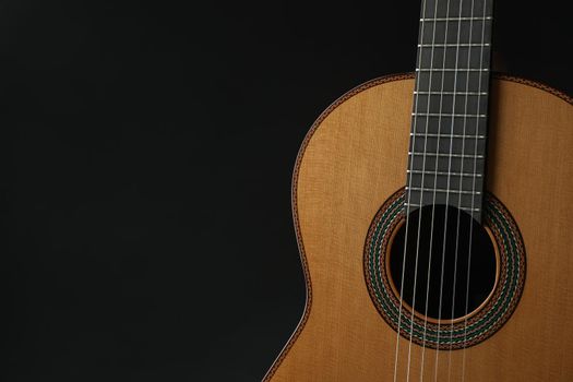 Beautiful six - string classic guitar against dark background, space for text