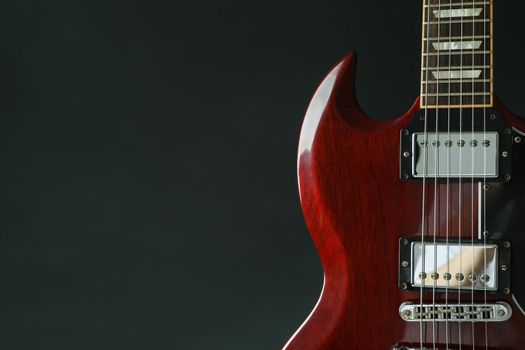 Beautiful six - string electric guitar against dark background, space for text