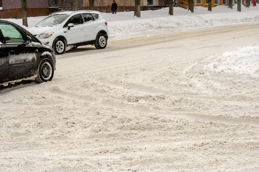 Stuck cars under the snow and ice. City street after blizzard. Buried vehicle in snowdrift on the road. Parking lots in winter after heavy snowfall. Uncleaned roads. Record-breaking amounts of snow.