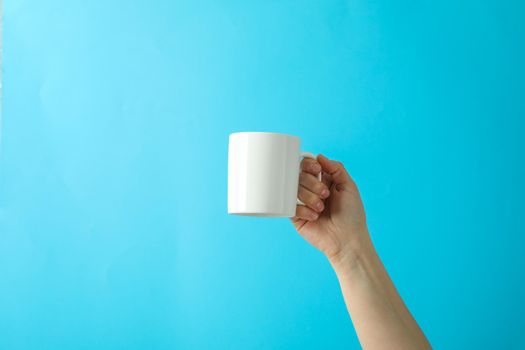 Female hand holding white cup against color background, space for text
