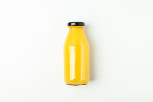 Fresh orange juice in bottle on white background, space for text. Fresh natural drink