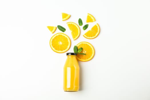 Flat lay composition with orange juice in bottle, orange pieces and mint on white background, space for text. Natural drinks and fruits
